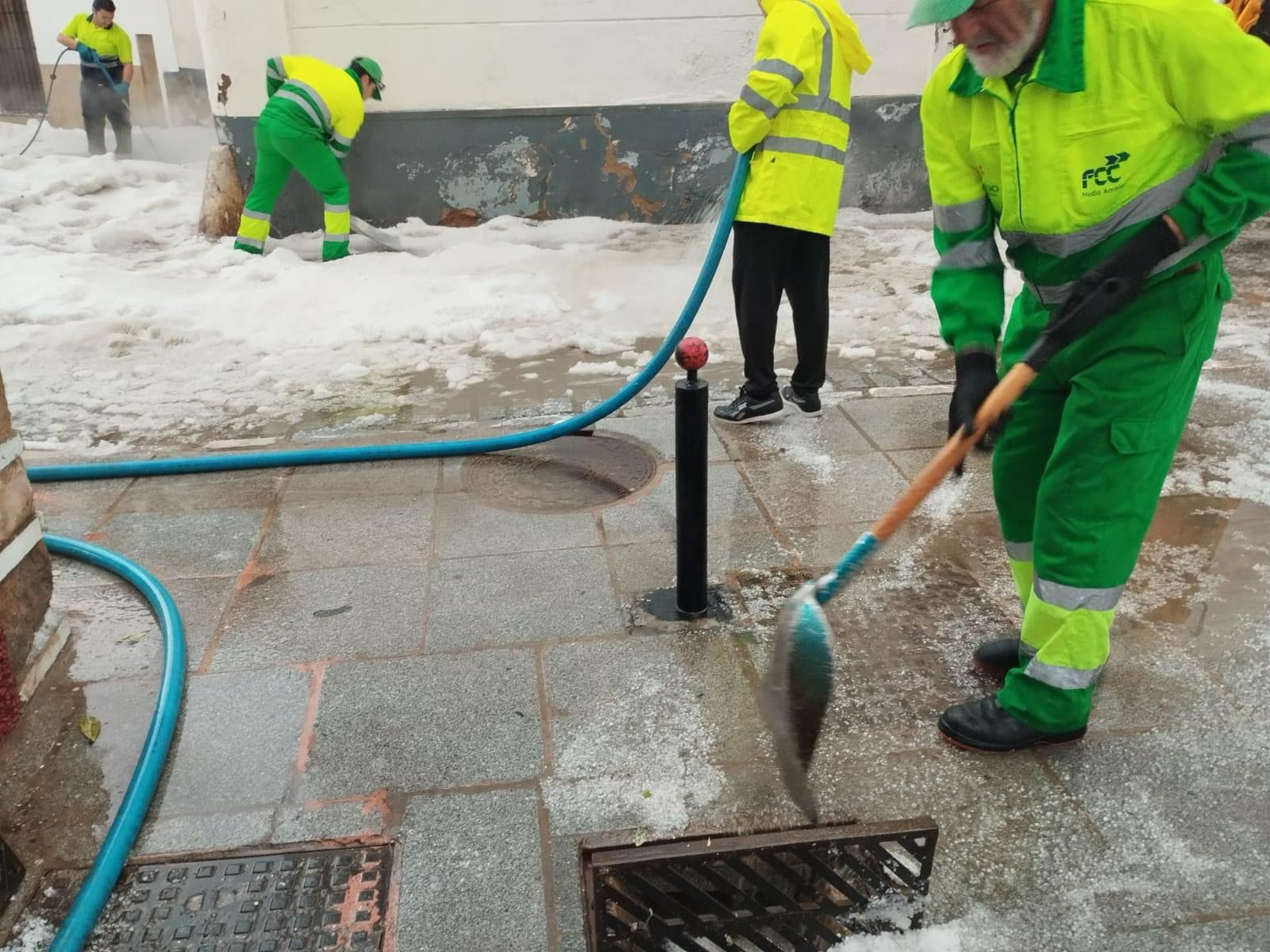 Trabajadores retirando el granizo acumulado.