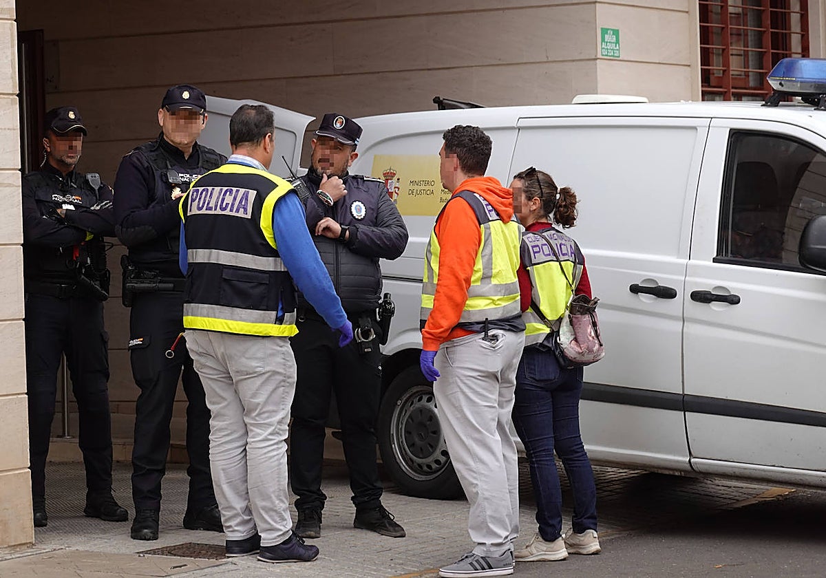 Los agentes policiales junto al furgón policial en el que fue retirado el cadáver.