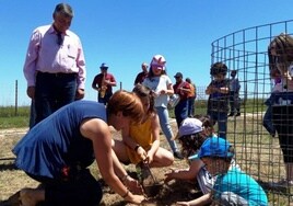 Niños plantando en la dehesa.
