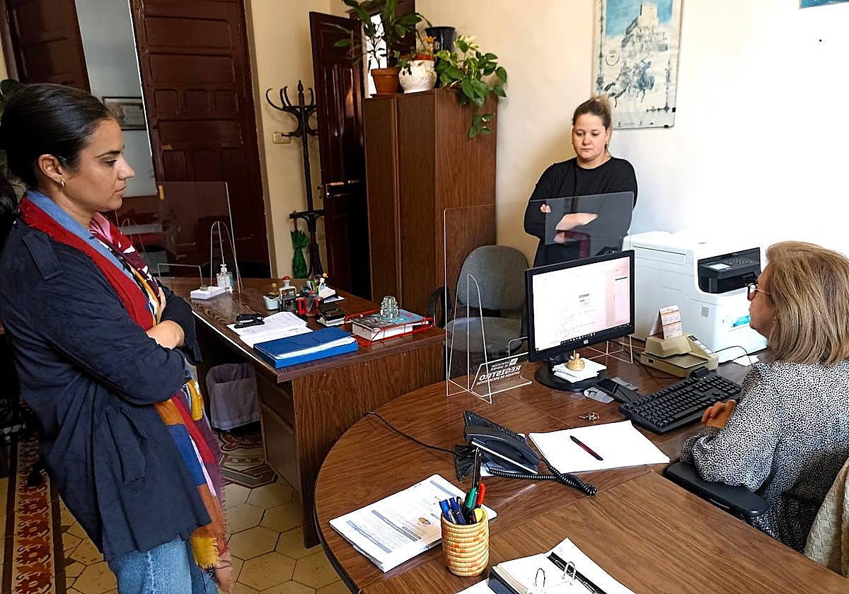 Dos concejalas observan el sorteo informático ejecutado por una empleada pública