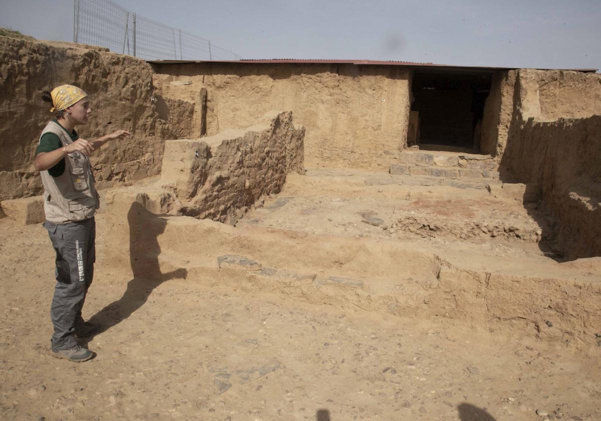 Una peón de arqueología explica detalles de la puerta este del complejo tartésico de Guareña.