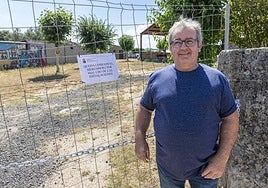 El alcalde de Oliva, Ángel González, delante de la valla y la cadena instaladas.