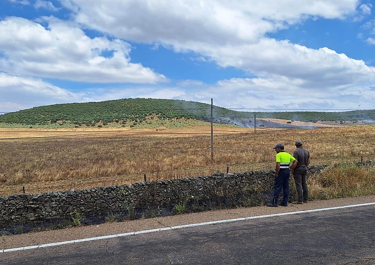 Imagen secundaria 1 - Arriba, bomberos y vecinos voluntarios, haciendo labores de extinción terrestres en la finca más afectada. Abajo, varios vecinos de Alconchel, sofocando otro foco aislado junto a la carretera.