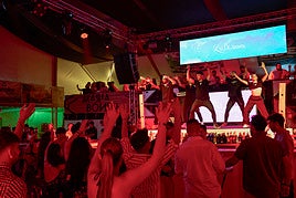 El público baila al compás de los animadores en una de las casetas de la feria.
