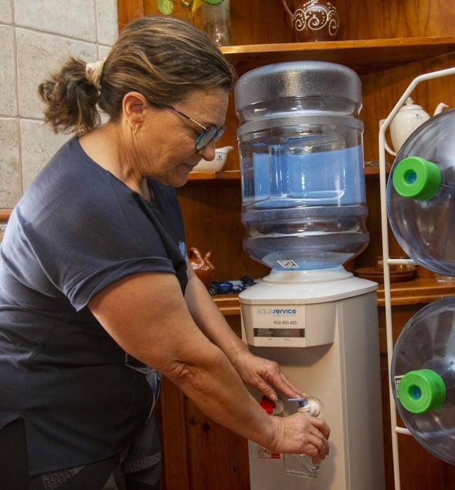 Basilia Aguado, con la máquina dispensadora de agua instalada en su domicilio.