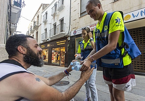 Voluntarios de DYA entregan el 'kit de hidratación' a un sintecho este jueves por la tarde en la calle Pintores.