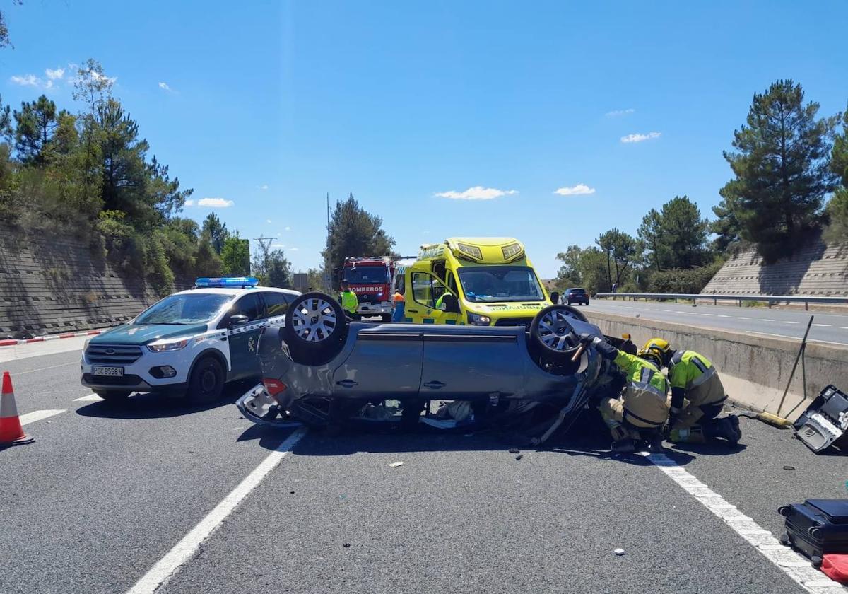 Bomberos trabajando en el lugar del accidente para excarcelar al joven que había quedado atrapado en el coche implicado en el accidente.