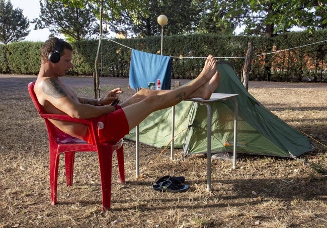 Un campista descansando junto a su tienda de campaña en el camping de Mérida.