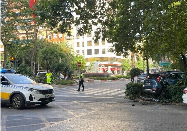 El coche empotrado contra el seto, a la derecha, y en primer término un vehículo policial.