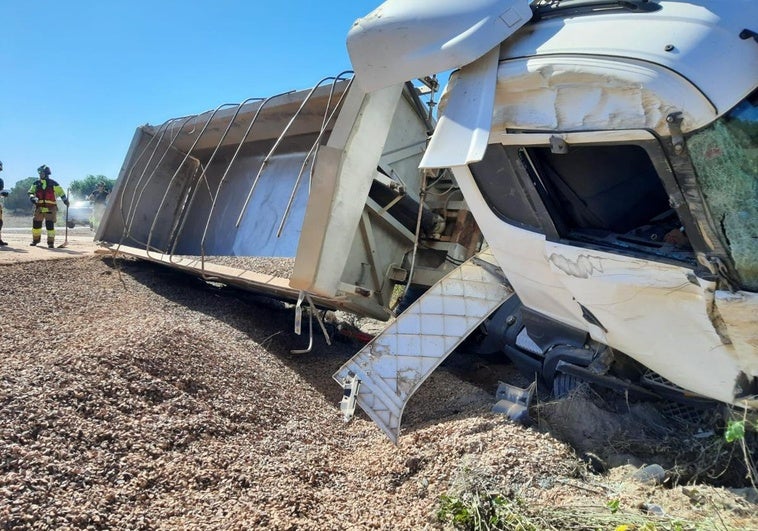 El camión se salió de la vía, volcó y perdió la carga de grava.