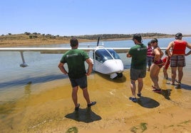 Bañistas junto a una hidronave, la primera que amerizó en el embalse de Alange, en junio de 2018.