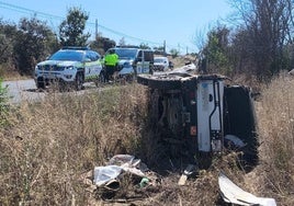 La Guardia Civil en el lugar del siniestro, con el vehículo volcado fuera de la calzada.