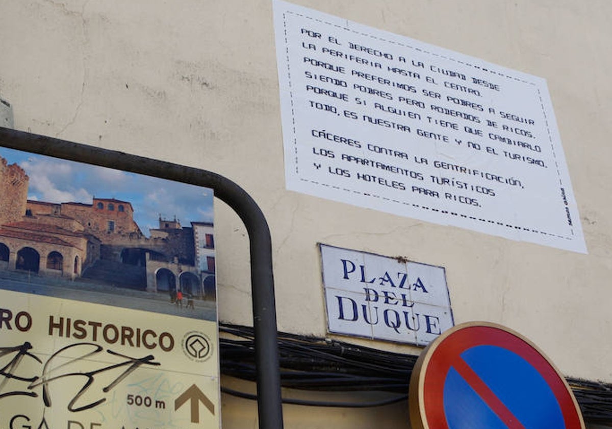 El cartel, sobre fondo blanco, ha aparecido pegado sobre una pared en la Plaza del Duque de Cáceres.