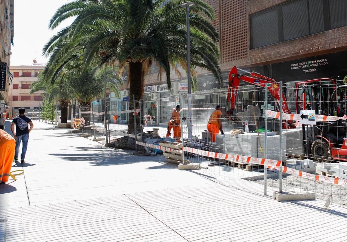 Trabajadores en la obra de la nueva calle peatonal, Rodriguez Moñino, con las palemeras en el centro de la plataforma única.