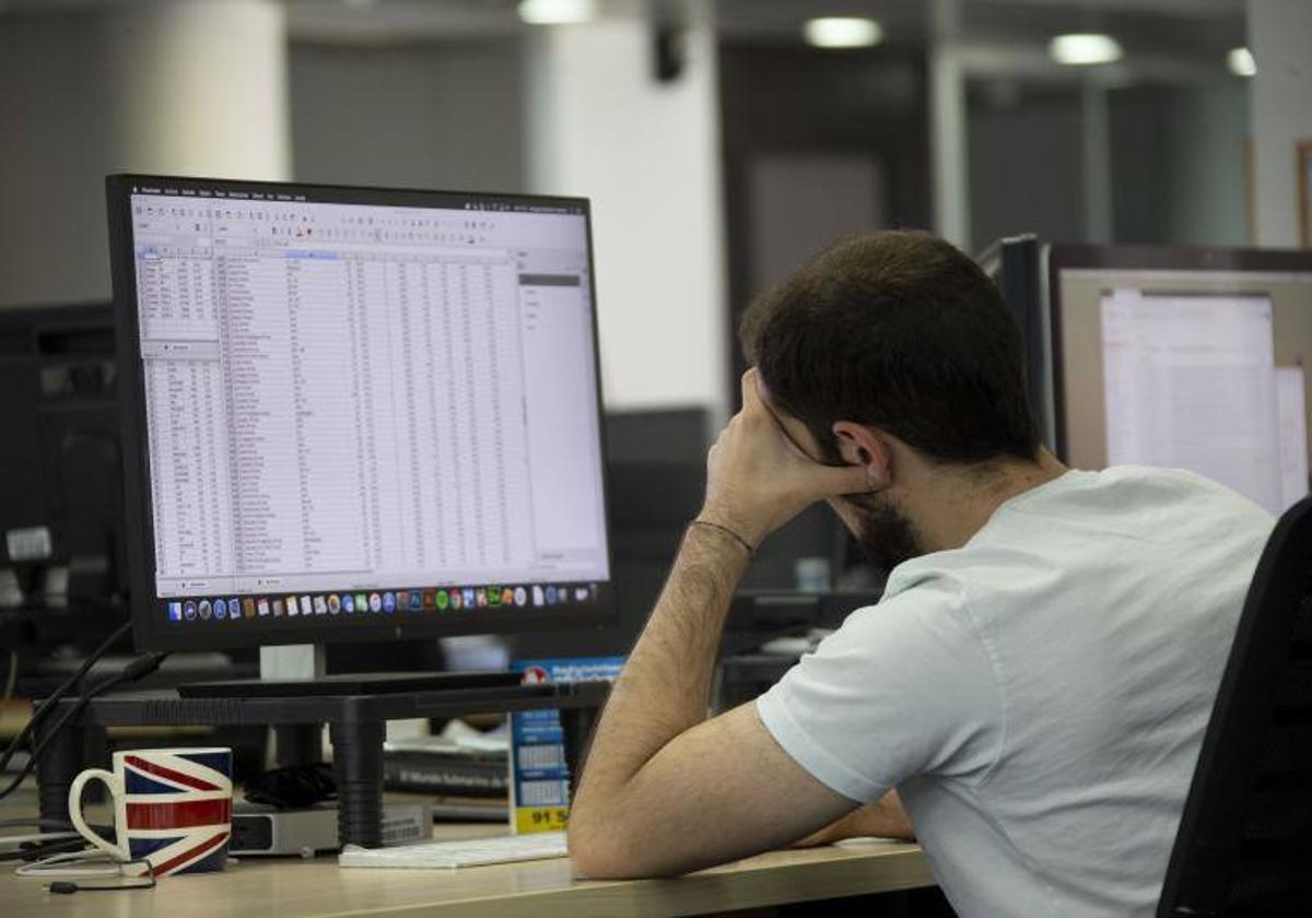 Un trabajador mira la pantalla de su ordenador en la oficina.