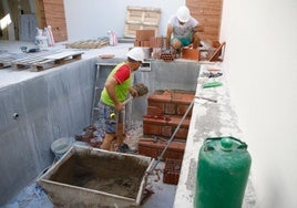 Un nuevo chalé Dos obreros construyen una piscina en el patio de una casa de Vistahermosa.