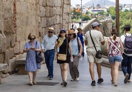 Turistas caminando junto a la Alcazaba árabe de Mérida.