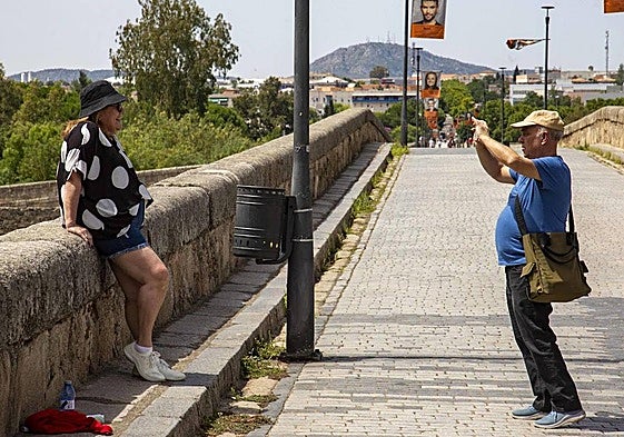 Una mujer es fotografiada en el puente Romano de Mérida.
