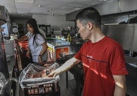 Liguang Yan toma la temperatura a los pollos que llegaron ayer a su local.