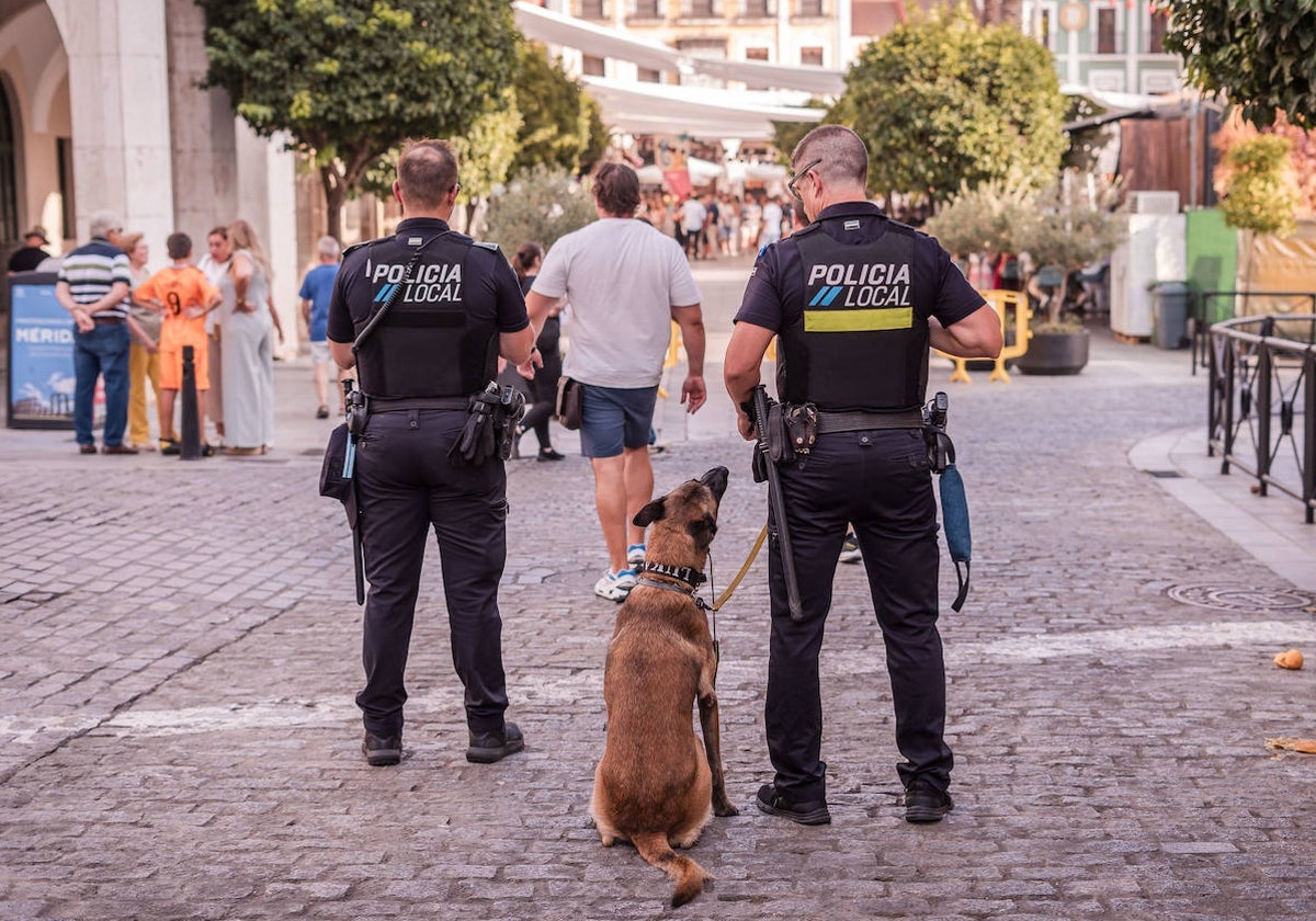 Dos agentes junto al perro de la Policía Local, este jueves, en la calle Santa Julia, frente a la plaza de España.