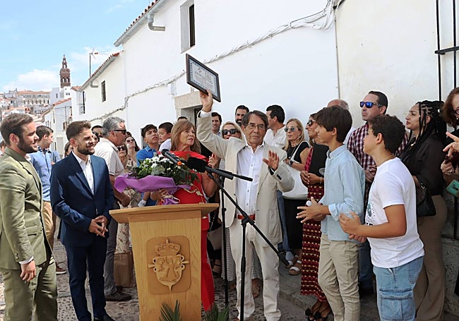 Correa recibiendo la réplica de la placa colocada en su casa.