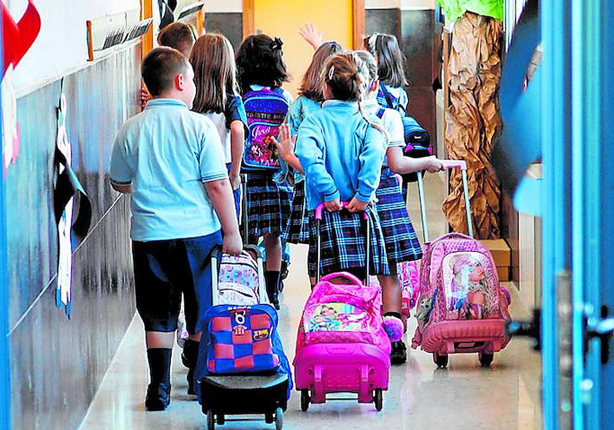 Un grupo de alumnos se dirigen a su clase en el primer día de colegio.