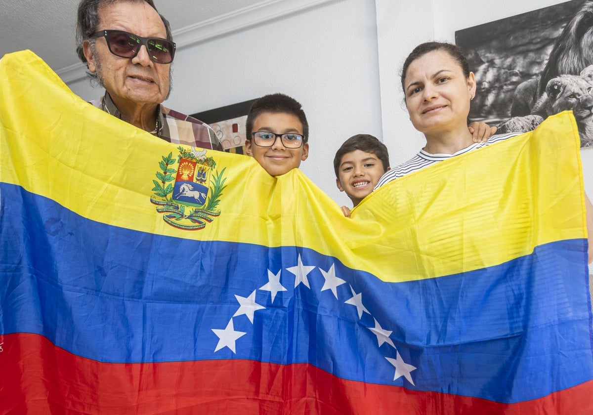 Juan Ramón Araujo, su mujer María Liliana y sus dos hijos, con la bandera de su país en su casa de Cáceres.