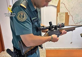 Un agente del Seprona con el rifle municionado intervenido.