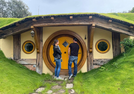 Los promotores de este proyecto, Iryna y Óscar, entran en una de las tres casas de la aldea hobbit que han creado en Villanueva de la Vera.