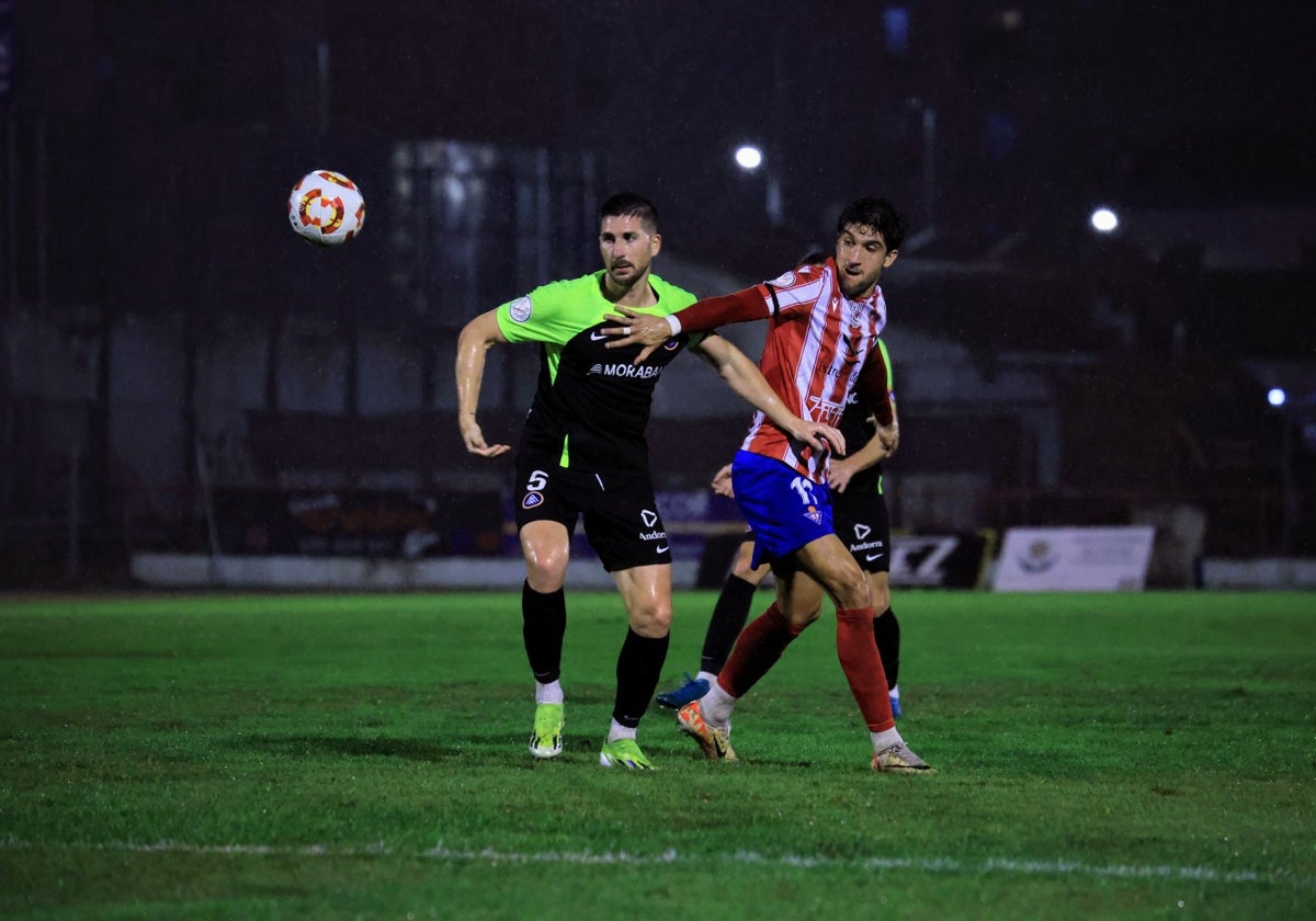 El jugador pacense del Andorra César Morgado disputa el balón con el rojiblanco Borja Domingo.