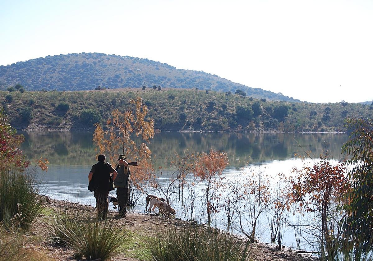 Dos cazadores junto a sus perros.