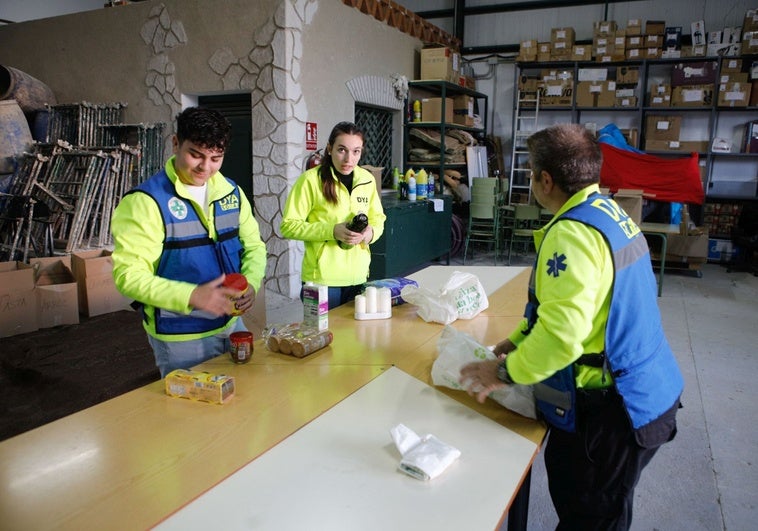 Voluntarios de DYA clasifican los primeros paquetes de ayuda que están llegando a las naves de CIFE este viernes.