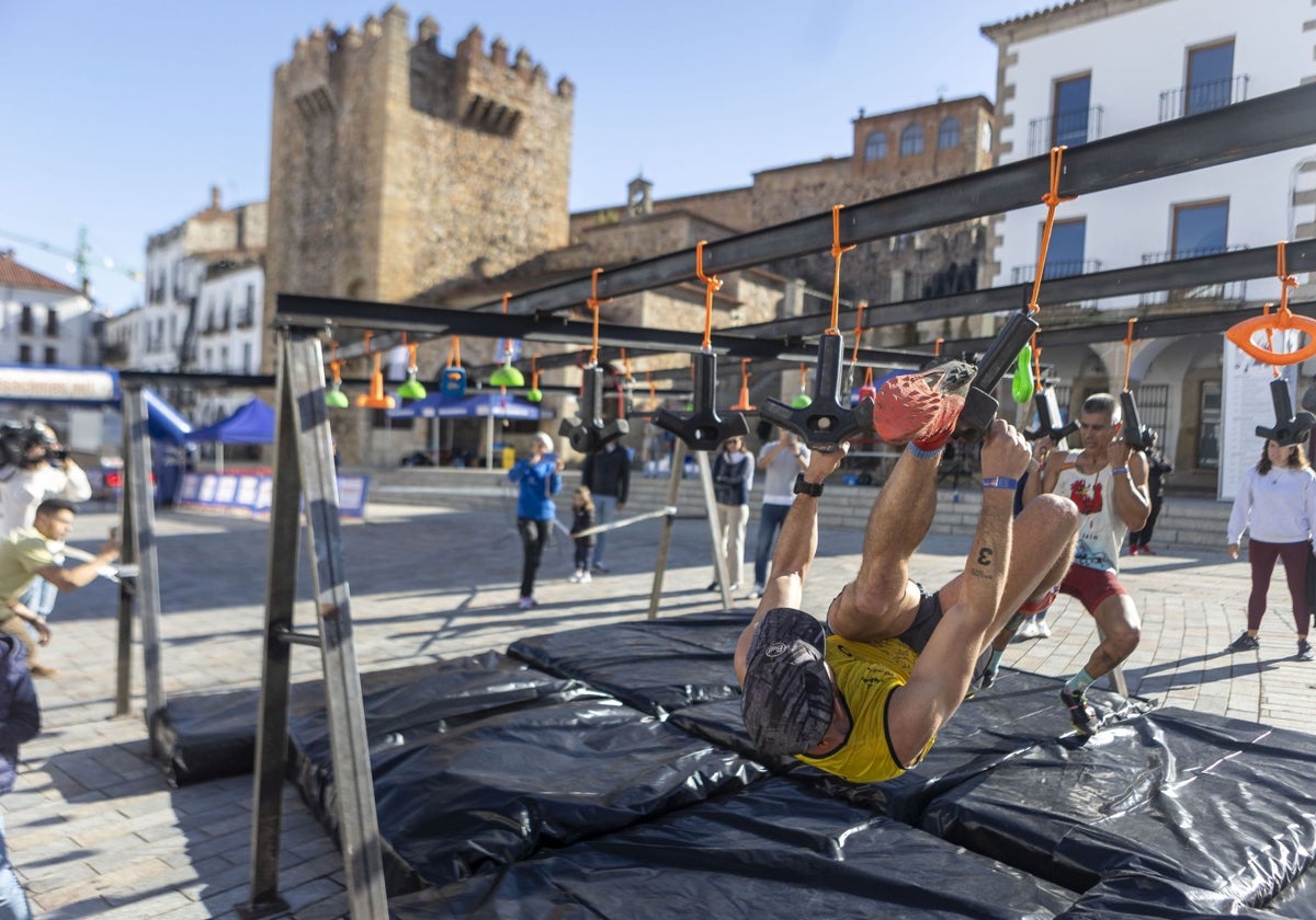 Dos de los participantes superando los obstáculos en la Plaza Mayor de Cáceres.