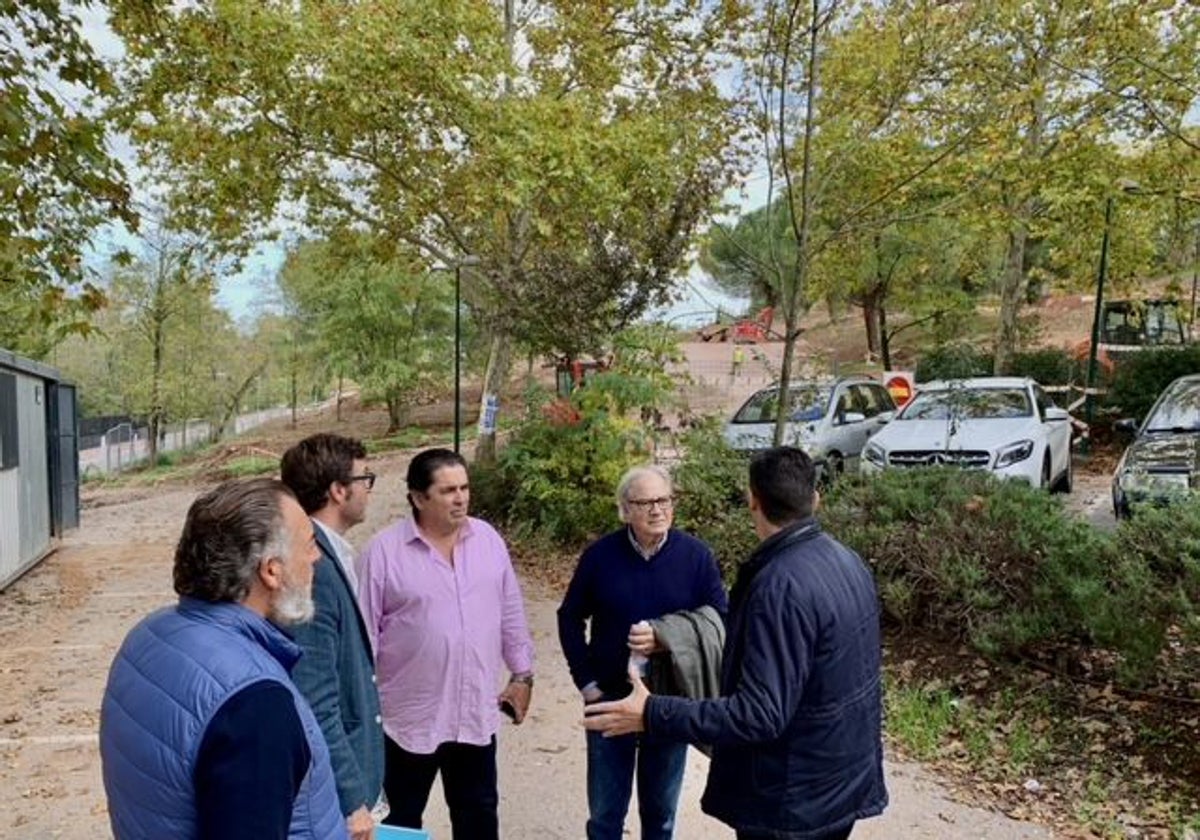 Representantes de Acaex, Julián Cruz, Florentino Suárez y Domingo Gil con los concejales Jorge Suárez (segundo a la izquierda) y Víctor Bazo (de espaldas), con la obra del aparcamiento al fondo.