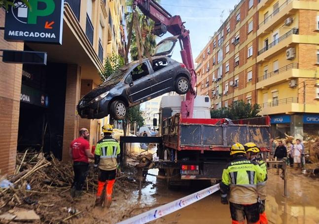 Bomberos de la Diputación de Badajoz sacando vehículos de un parking.