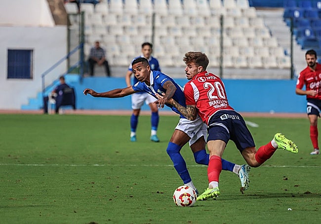 Iñaki León, del Coria, presiona al delantero Jeisson, del Melilla.
