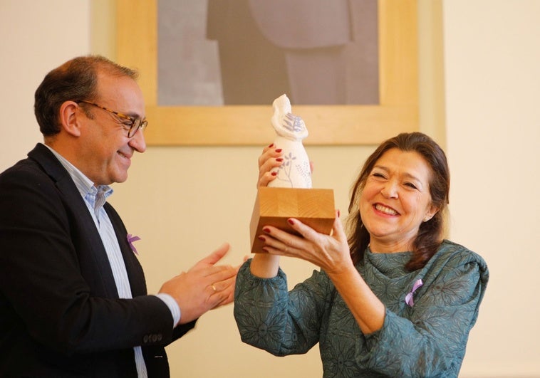 Nuria Gómez Carmona recibe el premio 25-N de manos de Rafael Mateos.