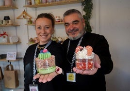 Arancha y Luis enseñan las velas aromáticas que ellos hacen y venden este mes en el mercado navideño del paseo de San Francisco.