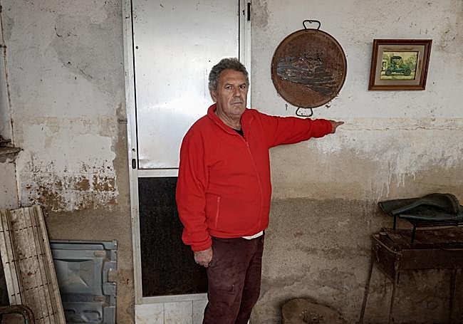 Enrique Vizuete señala hasta donde llegó el agua en su casa.