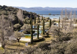 Zona de playa artificial del complejo residencia y de ocio, con el embalse al fondo.