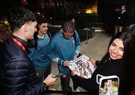 De Paul firma un autógrafo a una seguidora al mismo tiempo que le hacen una foto para inmortalizar el momento.