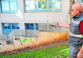 El trabajador de mantenimiento del edificio Zigurat con una de las piedras lanzada por jóvenes que hacen botellones por la zona.