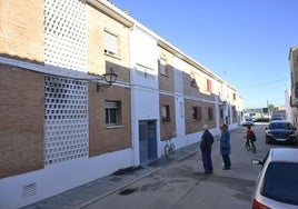 Varios vecinos de la calle Juan XXIII de Talavera la Real observan la vivienda que ha sufrido el incendio.