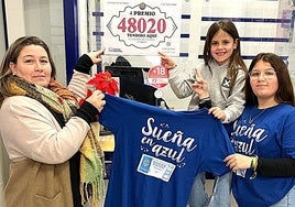 María con sus hijas Lucía la pequeña y Marta la mayor ante el número premiado y vendido en el centro receptor de su madre.