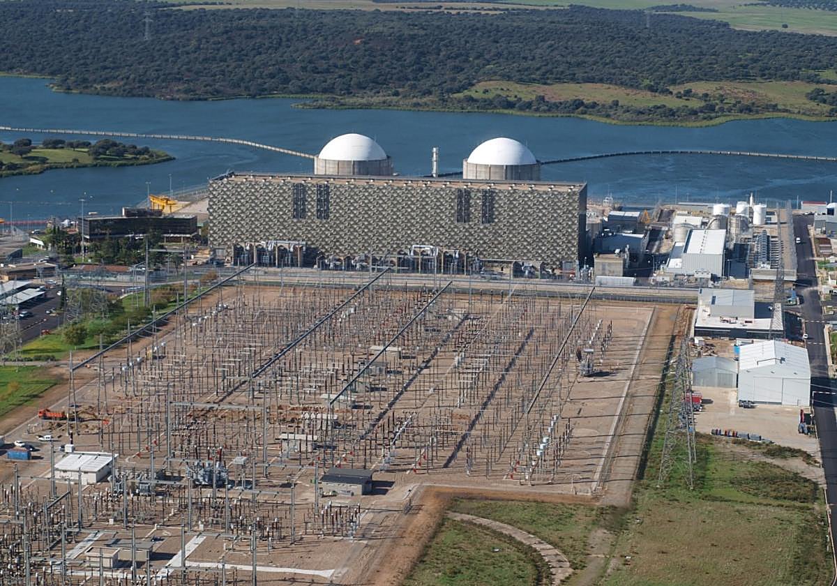 Vista aérea parcial de la planta extremeña, con las cúpulas de sus dos reactores y el embalse de Arrocampo tras ellas.