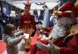 Una niña entrega su carta a Melchor, este sábado en el Paseo de Cánovas de la capital cacereña.