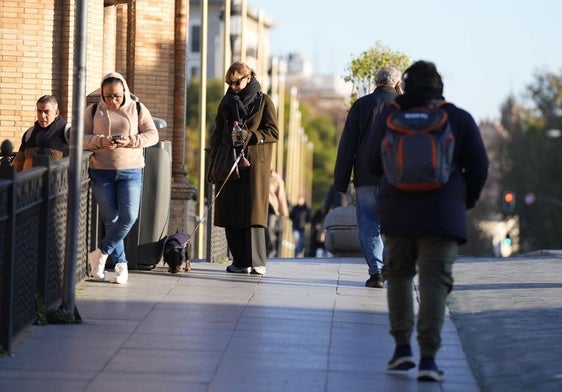 Personas abrigadas por las bajas temperaturas este martes, en Sevilla.