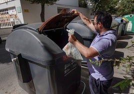 Un pacense deposita una bolsa de basura en el nuevo contenedor marrón.