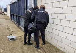 Dos policías nacionales toman huellas esta mañana en la entrada de la sede de Viñaoliva en Almendralejo.