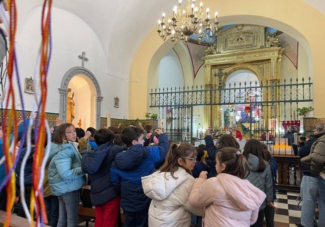Escolares del colegio público Santísimo Cristo de las Misericordias antes de recibir los cordones bendecidos de San Blas.